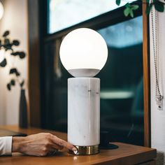 a person sitting at a table with a lamp on it