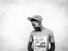 a black and white photo of a person wearing a baseball cap with the words thank you on it