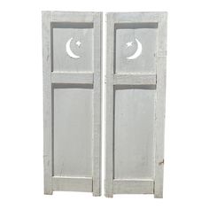 two white doors with moon and crescent cutouts on each side, one open to the other