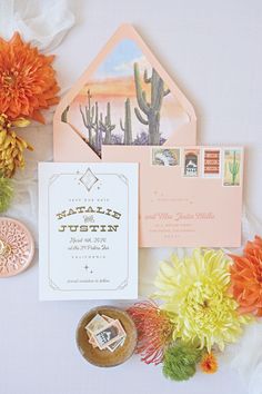 an image of wedding stationery with flowers on the side and cactus in the background