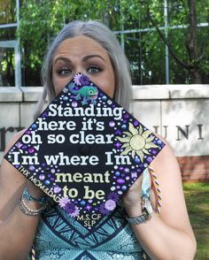 a woman holding up a graduation cap that says standing there it's oh so clear i'm where i'm meant to be