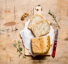 two pieces of bread sitting on top of a wooden cutting board next to a knife