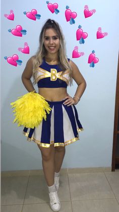 a woman in a cheerleader outfit posing for a photo with hearts on the wall behind her