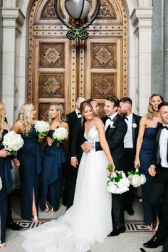 a group of people standing next to each other in front of a door with flowers