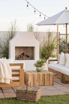 an outdoor fireplace and seating area with umbrellas