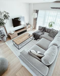 a living room filled with furniture and a flat screen tv on top of a wooden table