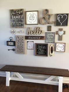 a wooden bench sitting in front of a wall filled with pictures and letters on it