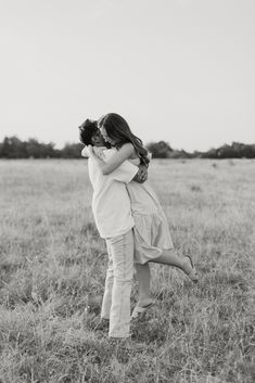 two women hugging in the middle of a field