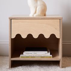 a white cat sitting on top of a wooden shelf