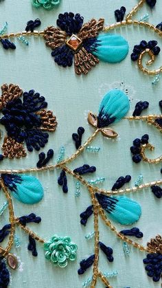 blue and gold embroidered fabric with flowers on it