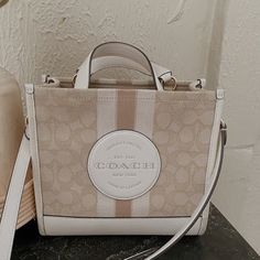 Coach Tote Bag In Great Used Condition Has Some Minor Wear On The Bottom ( Second Picture) But Can Be Cleaned Detachable Strap Measurements: Length: 8.75" Height: 6.25" Width: 4.25" Coach Beige Rectangular Bag, Coach Beige Shoulder Bag Large Capacity, Large Capacity Coach Beige Bag, Coach Beige Shoulder Bag With Large Capacity, Coach Beige Large Capacity Shoulder Bag, Chic Cream Coach Shoulder Bag, Coach Beige Shoulder Bag With Dust Bag, Beige Coach Shoulder Bag With Dust Bag, Chic Coach Shoulder Bag With Large Capacity