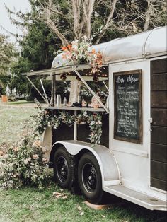 the food truck is decorated with flowers and greenery