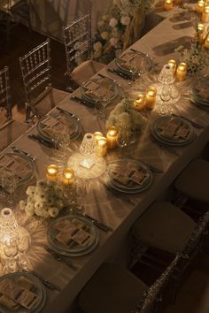 a long table is set with candles and place settings for dinner guests to enjoy the meal