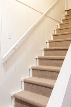 there is a cat that is sitting on the stairs next to the bannister