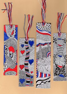 four bookmarks with designs on them hanging from strings in front of a beige background