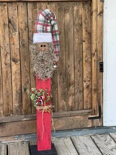 a wooden pole with a santa clause on it and a planter in front of the door