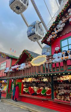 people are standing in front of a carnival ride at the amusement park with christmas decorations on it