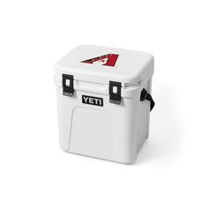 the yeti cooler is white with black handles and two blue letters on it's side