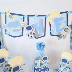 a birthday party with blue and white decorations, including an astronaut themed cake topper