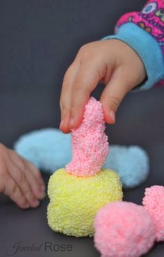 a child's hand is reaching for some kind of cake that looks like a cone