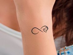 a woman's arm with a tattoo on it that has a heart in the middle