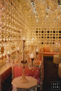 the chandelier is hanging from the ceiling in this fancy room with pink chairs