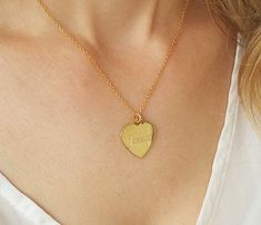 "Engrave the name of someone close to your heart with our gold engraved heart necklace. This simple, yet sophisticated love necklace is the perfect piece to show someone just how much you care. The 14k gold filled heart charm can be engraved with a name or initial of your choice. Featuring a high-shine finish and clean lines, this timeless charm hangs from a delicate 14k gold filled link necklace. Treat yourself to this lovely piece or give it to that someone special to show them just how import Personalized Heart Necklace With Engraving For Mother's Day, Personalized Engraving Heart Necklace For Mother's Day, Valentine's Day Engraved Necklace Gift For Mom, Heart Pendant Necklace With Engraving For Mother's Day, Heart-shaped Engraved Name Necklace For Mom, Custom Name Heart Pendant Necklace For Wedding, Mother's Day Heart Pendant Necklace With Engraving Option, Elegant Engraved Heart Necklace For Mom, Elegant Engraved Heart Necklace As Gift For Mom