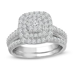 a white gold ring with diamonds on the band and an oval shaped center stone in the middle