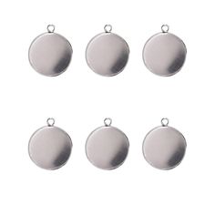 six silver tone round charms on a white background