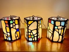 three stained glass lamps sitting on top of a wooden table