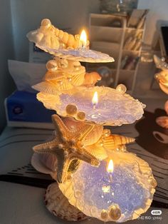 three seashells with candles in them on a table