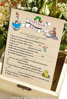 a wooden box with a story book quiz sign in it's center surrounded by flowers