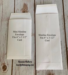 two envelopes with measurements on them sitting next to each other in front of a wooden table