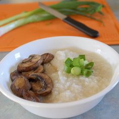 a bowl filled with rice and mushrooms on top of a counter next to a knife