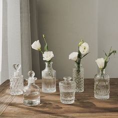 several glass vases with flowers in them on a table