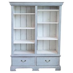 a white bookcase with two drawers and one door on the front, against a white background