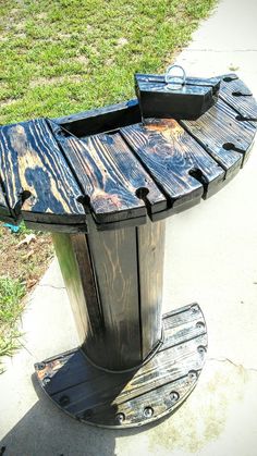 a wooden bench sitting on top of a sidewalk next to a grass covered park area