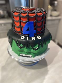 a birthday cake with the number four on it's top and monster face decoration