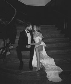 black and white photo of bride and groom sitting on the stairs at their wedding reception