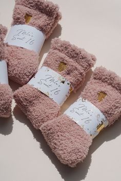 four pairs of pink mittens with writing on them