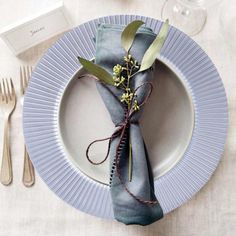 a place setting with silverware and napkins