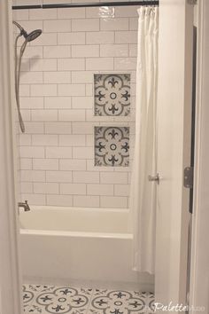 a bathroom with black and white tile on the floor, shower curtain, and bathtub