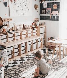 a little boy sitting on the floor in front of a dresser