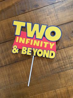 two infinity and beyond sign on wooden floor with lollipop stick sticking out