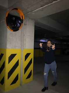 a man standing next to a yellow and black barricade in a parking garage