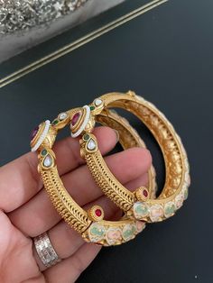 Classic & Elegant Pastel Meenakari Openable Bangle Pair in Antique Gold Finish studded with Kundan, Ruby stones & pearl piroyi. Pair this gorgeous Openable Bangles with any Traditional Indian Ethnic wear to get lot of compliments on your way. Available in size 2.4 & 2.6, great fit for bangle size 2.4-2.8 ✅Check other styles available in our store  https://www.etsy.com/shop/KKsCulture Send us an email if you need help!  SHIPPING & TURNAROUND  We follow item dispatch in 1-2 business days for most of our shipments. All pre orders will take approximately 3 weeks. We offer Free domestic delivery across US. Most deliveries are done in 2-5 business days via USPS. For any other query or assistance with shipping, please write to us.  ❤️ Whenever you buy something from a small business you are not o Ruby Bangles, Ruby Stone, Indian Ethnic Wear, Classic Elegant, Traditional Indian, Ethnic Wear, Gold Finish, 3 Weeks, Green And Gold