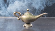 a metal teapot with steam coming out of it's top on a table