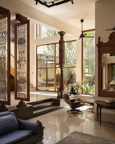 a living room filled with furniture next to large windows and lots of wood trimming