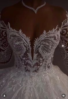 the back of a white wedding dress with beading and lace on it's shoulders