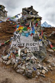 there is a large rock with many flags on it